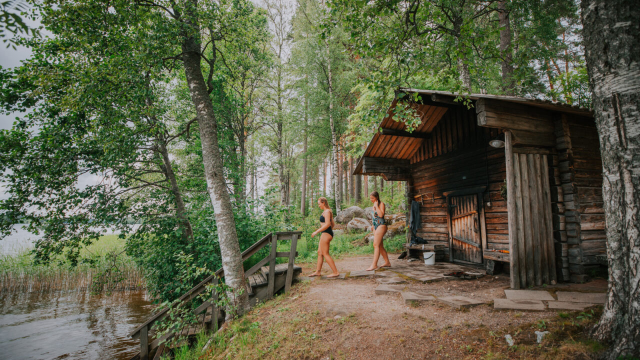 Two persons walking from the sauna in order to have a swim in the lake