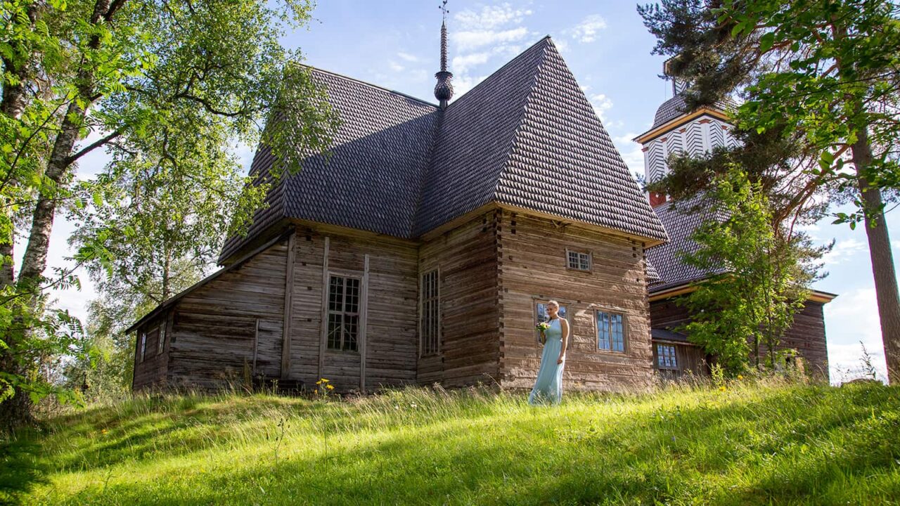Ihminen seisoo Petäjäveden vanhan kirkon edessä